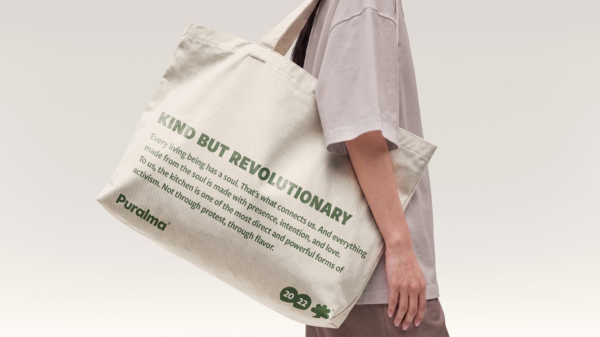Puralma. A tote bag reading "Kind but revolutionary," carried over the shoulder.