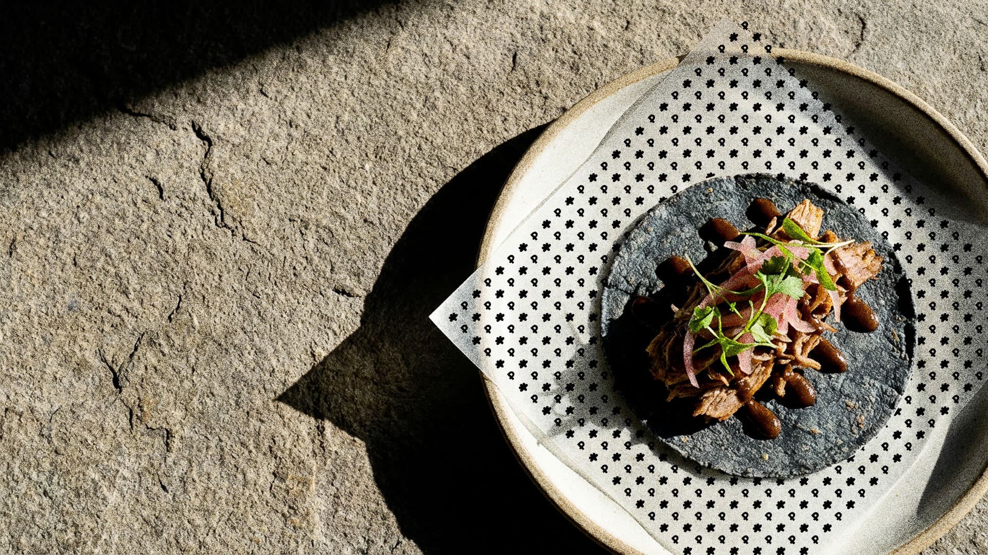 Puralma. A taco on a blue corn tortilla, on a patterned napkin.